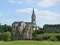 Vestiges de la chapelle castrale Saint-Vincent, et église contemporaine en arrière-plan.