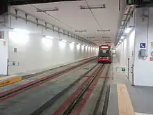 Une rame du tramway s'éloignant dans un tunnel à double sens, bien éclairé.