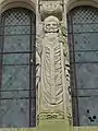 Statue de saint Médard sur la façade de l'église.