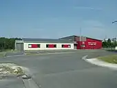 Photographie en couleurs de bâtiments et garages peints en blanc et rouge.