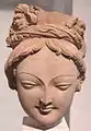 Tête de bodhisattva à la tiare ornée de grotesques. Tumshuq, Toqquz-Saraï, IVe – Ve&nbsp;siècle. H. 16&nbsp;cm. Musée Guimet