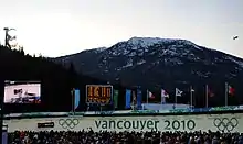 Photo du virage d'une piste de bobsleigh avec une montagne en arrière-plan.