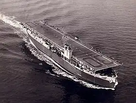 Photo en noir et blanc de trois quarts dessus d'un porte-avions d'escorte.