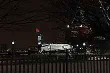 Photo de nuit montrant l'avion, aux couleurs bleues et blanches, sur la berge.