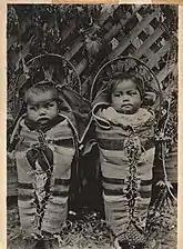Enfants umatillas dans des porte-bébés sur planches