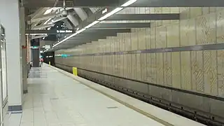 Vue de toute la longueur du quai. Une caméra de vidéosurveillance est visible au premier plan.
