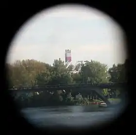 La cheminée de l’usine vue du centre-ville vue des jumelles touristiques installées sur le Pont-Neuf, d’une distance d’environ 3,8 km.