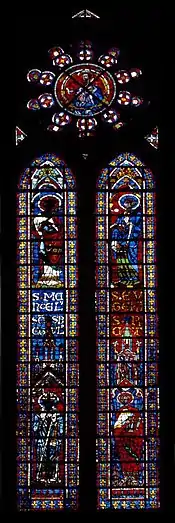 Verrière en deux lancettes de 45 panneaux vitrés. Chaque lancette, en verres de couleur en partie noircies, représente deux saints