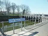 De Veurne-Ambachtvaart, met rechts de spuisluis