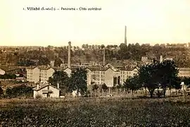 Vue d'une cité ouvrière sur une carte postale ancienne : petits immeubles collectifs et cheminées d'usines.