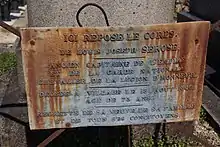 Vue de deux plaques posée sur une tombe dans un cimetière