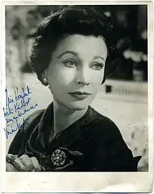 Portrait en noir et blanc d'une femme habillée de couleurs sombres. La photographie est dédicacée.