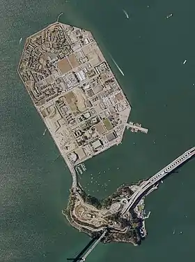 Photo aérienne de la petite île naturelle « Yerba Buena Island » (au sud) surplombée par l'île artificielle de Treasure Island